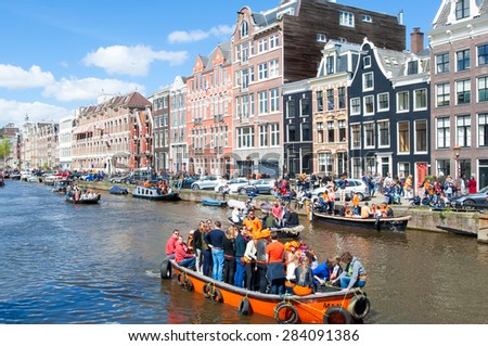 AMSTERDAM-APRIL 27: The celebration of King\'s Day on a boats along the Singel canal on April 27,2015, the Netherlands. King\'s Day is the biggest festival celebrating the birth of Dutch royalty.