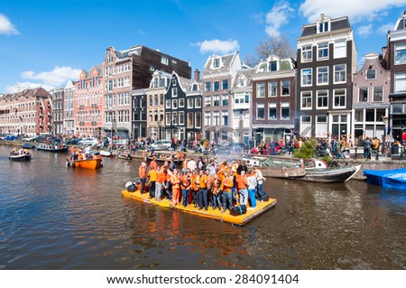 AMSTERDAM-APRIL 27: Happy People celebrate King\'s Day along the Singel canal on the orange raft on April 27,2015. King\'s Day is the biggest festival celebrating the birth of Dutch royalty.