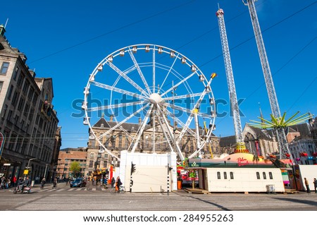 AMSTERDAM,NETHERLANDS-APRIL 27: Ferris wheel on Dam Square on the eve of King\'s Day on April 27,2015 in Amsterdam.  King\'s Day is the largest open-air festivity in Amsterdam.