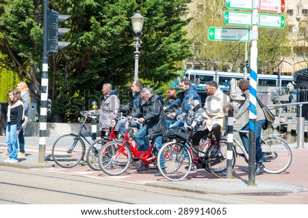 AMSTERDAM-APRIL 30: Locals on bicycles stop at traffica light on April 30,2015, the Netherlands. There are more bicycles then people in Amsterdam.