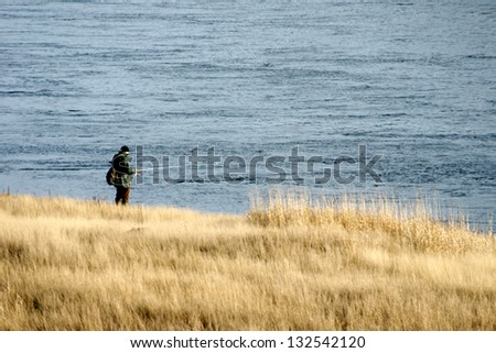 Its autumn: an angler fishes by a river/fishing by the river