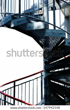 A spiral staircase, fire escape on the side of a building facade/Spiral staircase