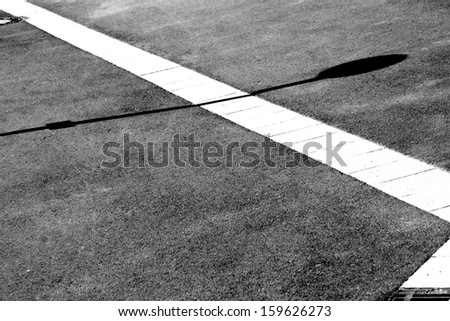 The photograph of a sidewalk in the sunlight with Gully drains and shadows / Sidewalk top view