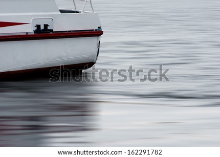 The photograph of a boat-tail driven on a smooth water surface / Boat-tail