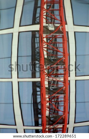 The photograph of windows in which are a facade with a crane arm mirrored / Curved facade