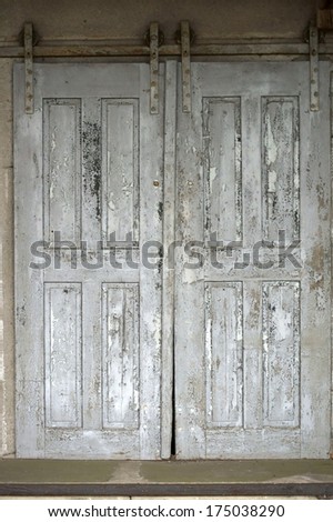 The photograph of an old sliding door of the ruin of an agriculture and storage building / Old sliding door