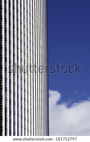 The photograph of a high-rise building facade against the light with clouds and sky / Facade and clouds