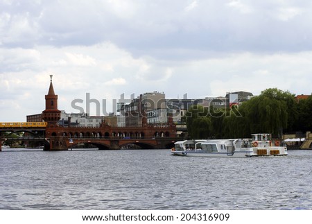 BERLIN, GERMANY - JUNE 16: A yellow tram crosses the Warsaw  Bridge over the river Spree on June 16, 2014 in Berlin / Warsaw Bridge
