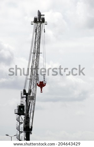 The photograph of a hoisting crane at a harbor / Lift crane
