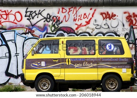 BERLIN, GERMANY - JUNE 16: An old Volkswagen minibus of Eastern Comfort Hostelboat stands on the the East Side Gallery on June 16, 2014 in Berlin / Old Volkswagen minibus