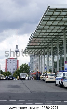 BERLIN, GERMANY - JUNE 16: Taxis and police cars parked in front of the glass entrance of the Berlin East station with the TV Tower on June 16, 2014 in Berlin / Berlin East Railway station
