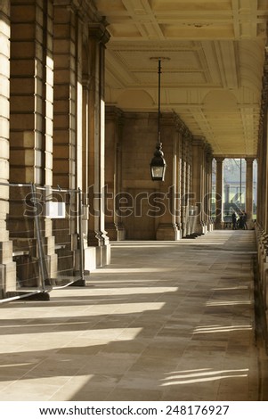 LONDON, UK - NOVEMBER 29: Column throw shadows in a corridor of the Royal Naval College in Greenwich where tourists standing at this end on November 29, 2014 in London / Royal Naval College