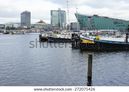 AMSTERDAM, THE NETHERLANDS - DECEMBER 31: The open harbor front with the technology Nemo, moored boats and modern buildings on December 31, 2014 in Amsterdam / Open waterfront Amsterdam