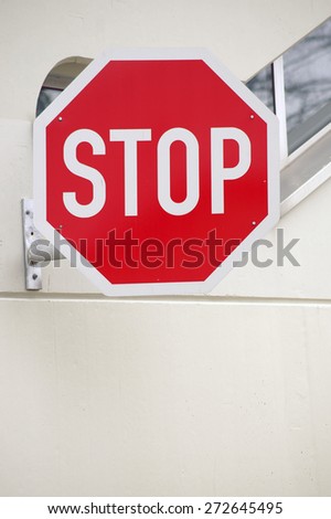 A strong colored stop sign on the facade of a building / Stop sign