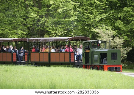 BERLIN, GERMANY - MAY 06: The park railway and train of the Britz Garden in Berlin\'s district Neukoelln with visitors and tourists on May 06, 2015 in Berlin / Park train Britz Garden
