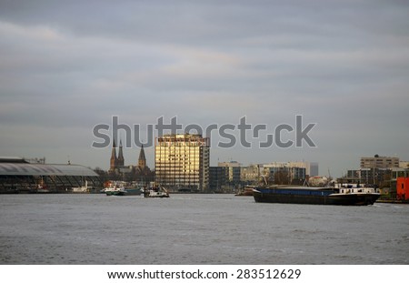 AMSTERDAM, NETHERLANDS - DECEMBER 29: The view of the timber port in Amsterdam with transport boats and view of the main railway station December 29, 2014 in Amsterdam / Timber Port Amsterdam