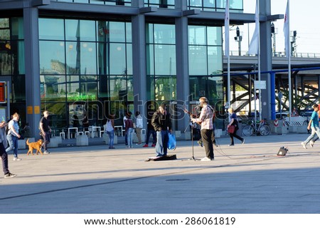 BERLIN, GERMANY - JUNE 04: A street musician plays for travelers on the guitar and is singing at the Berlin Station for money on June 04, 2015 in Berlin / Street musician in Berlin