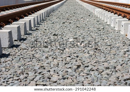 The road bed of a newly laid rail track for a tram with rails and gravel underlay / Road bed
