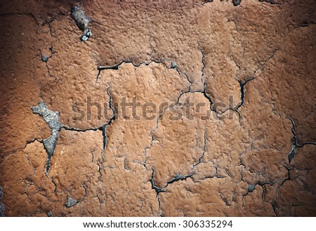 The closeup of peeling layers of plaster and paint on a concrete wall / Flaking plaster layer