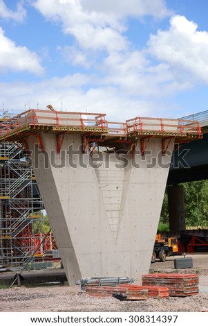 The construction of a new highway bridge with a V-shaped concrete beam / Bridge construction site