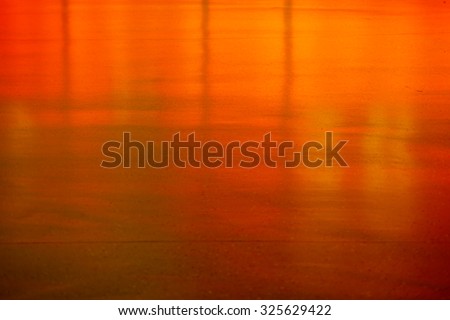 An orange and neon reflective smooth floor in front of a bar / Abstract floor