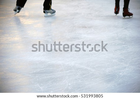 The close-up of the skates from ice skaters on an ice surface / Ice skating