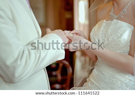 bride groom wears wedding ring on his hand