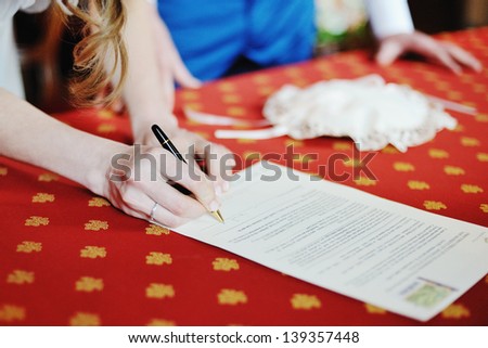 bride signing marriage license or wedding contract