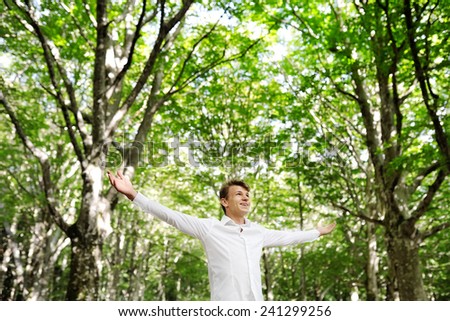 young free man enjoying nature in a forest - freedom happiness concept