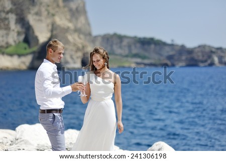 young bride and groom making a toast with champagne near sea, Naples, Italy