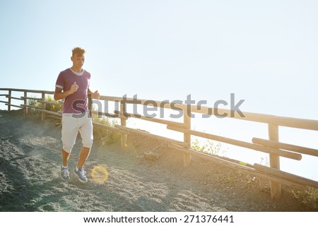 young man runs on a mountain trail