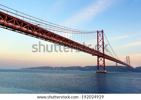 Red bridge at the sunset ( 25 de Abril Bridge and Cristo Rei statue ), Lisbon, Portugal