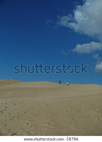 two man running up a dessert like sand dune