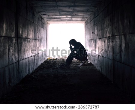 depressed man sitting in the tunnel
