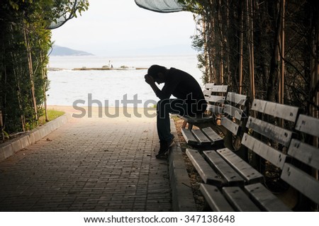 depressed young man sitting on the bench