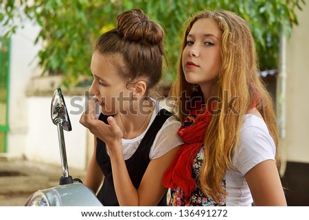 two young girls near the mirror scooter