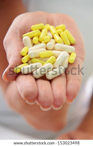 Women. Macro. Face and hands with a lot of pills
