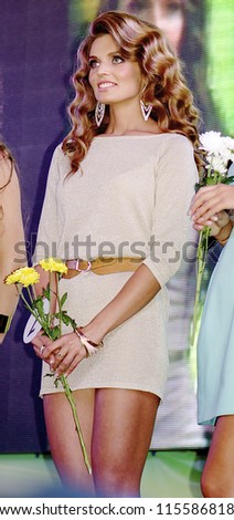 ST. PETERSBURG, RUSSIA - OCTOBER 13: Beautiful brunette girl with flowers during final stage of the contest Russian Beauty on October 13, 2012, in St.Petersburg, Russia