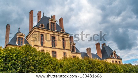 French Castle of Fontainebleau behind the trees-