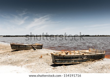 Two boats for sailing on the coast of the pink lake in Africa