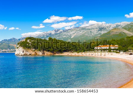 Blue water and the clean sand beach with the rock with plenty of trees. Resort on the Adriatic Sea