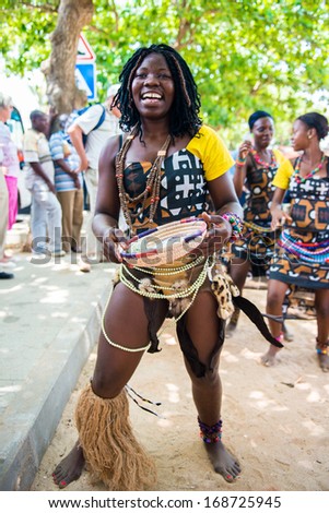 ANGOLA, LUANDA - MARCH 4, 2013: A smiling Angolan woman dances the local folk dance and collects money in Angola, Mar 4, 2013. Music is one of the main African entertainments.