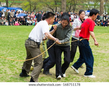 NORTH KOREA - MAY 1, 2012: Korean people jump over a skipping rope during the celebration of the International Worker\'s Day in N.Korea, May 1, 2012. May 1 is a national holiday in 80 countries