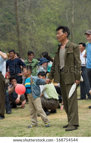 NORTH KOREA - MAY 1, 2012: Korean father and son during the celebration of the International Worker\'s Day in N.Korea, May 1, 2012. May 1 is a national holiday in 80 countries