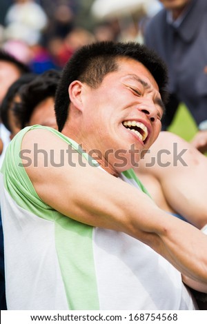 NORTH KOREA - MAY 1, 2012: Korean man participates in the tug of war game during the celebration of the International Worker\'s Day in N.Korea, May 1, 2012. May 1 is a national holiday in 80 countries