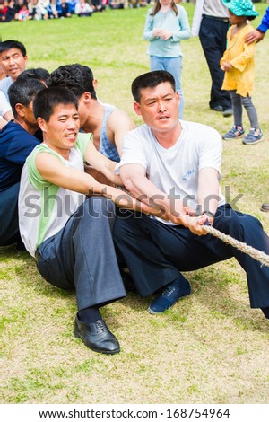 NORTH KOREA - MAY 1, 2012: Korean people participating in tug of war game during the celebration of the International Worker\'s Day in N.Korea, May 1, 2012. May 1 is a national holiday in 80 countries