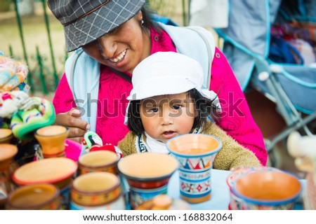 PERU - NOVEMBER 7, 2010: Undientified Peruvian girl helps her mother to sell stuff at the maket in Peru, Nov 7, 2010. Over 50 per cent of people in Peru live below the the poverty line.