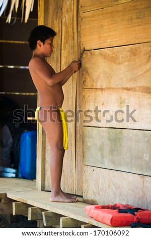 EMBERA VILLAGE, PANAMA, JANUARY 9, 2012: Unidentified native Indian boy works in a cabin in Panama, Jan 9, 2012. Indian reservation is the way to conserve native culture,