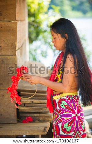 EMBERA VILLAGE, PANAMA, JANUARY 9, 2012: Unidentified native Indian woman makes flower decoration in Panama, Jan 9, 2012. Indian reservation is the way to conserve native culture