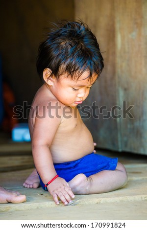 EMBERA VILLAGE, PANAMA, JANUARY 9, 2012: Portrait of an unidentified native Indian little boy playing in a cabin in Panama, Jan 9, 2012. Indian reservation is the way to conserve native culture